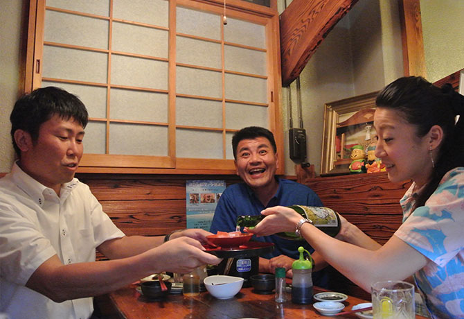 客人に焼酎を注ぐ女性