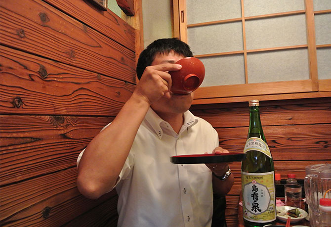 焼酎を飲み干す男性