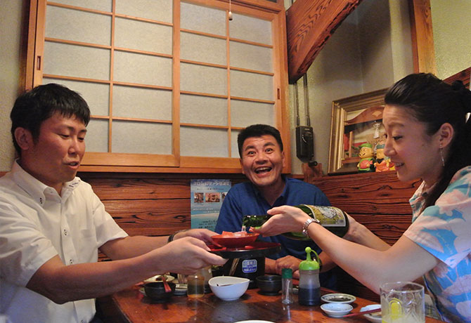 客人に焼酎を注ぐ女性