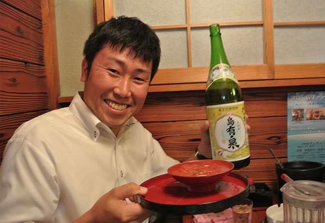 黒糖焼酎・島有泉を手に持つ男性