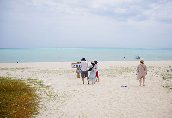 浜辺に立つ百合ヶ浜の看板